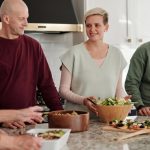Family members preparing and enjoying a meal together in a cozy kitchen setting.